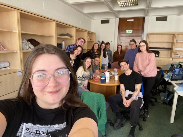 A selifie with a group of about 10 people in the background
